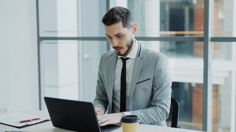 Profissional de terno trabalhando no notebook em um escritório